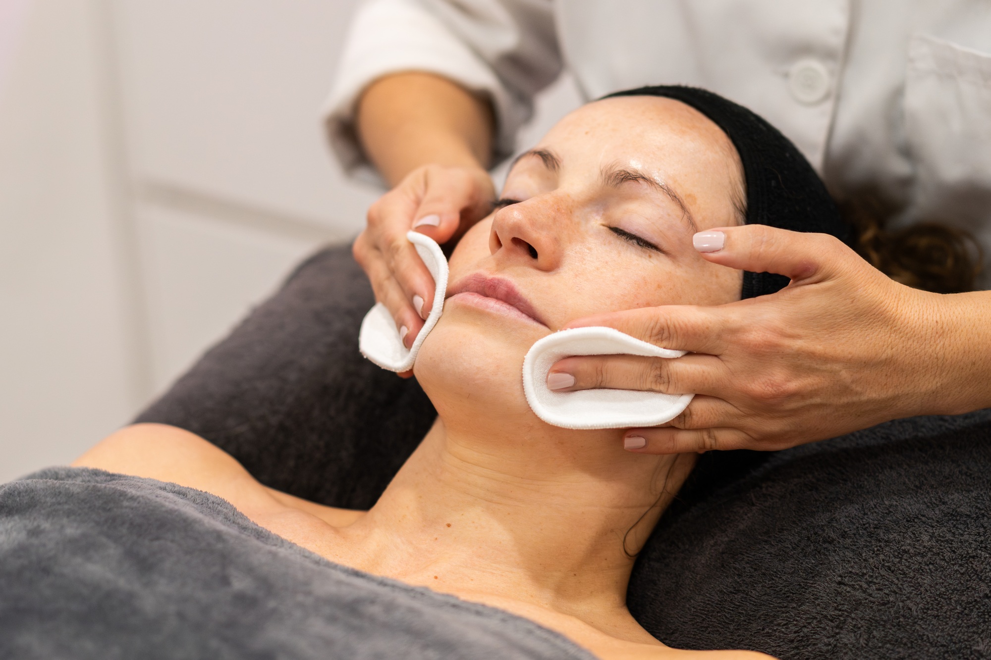 Relaxed woman having facial beauty treatment in spa center